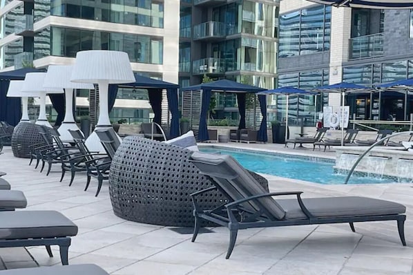 Relax by the pool surrounded by comfortable lounge chairs and umbrellas.
