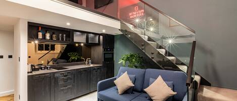 A modern kitchen with dark cabinetry, a built-in oven, and a countertop with a sink.