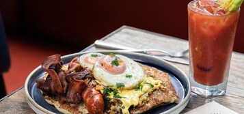 A breakfast plate with eggs, bacon, and toast, and a glass of iced tea.