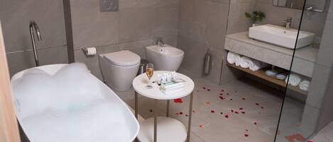 A modern bathroom with a freestanding bathtub, a round vanity with a sink, and a glass-enclosed shower area.