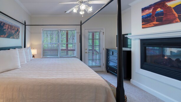 A four-poster bed, a fireplace, and a painting of a rock formation.