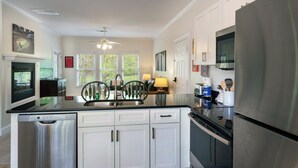 Una cocina moderna con lavavajillas, estufa, refrigerador y ventilador de techo.