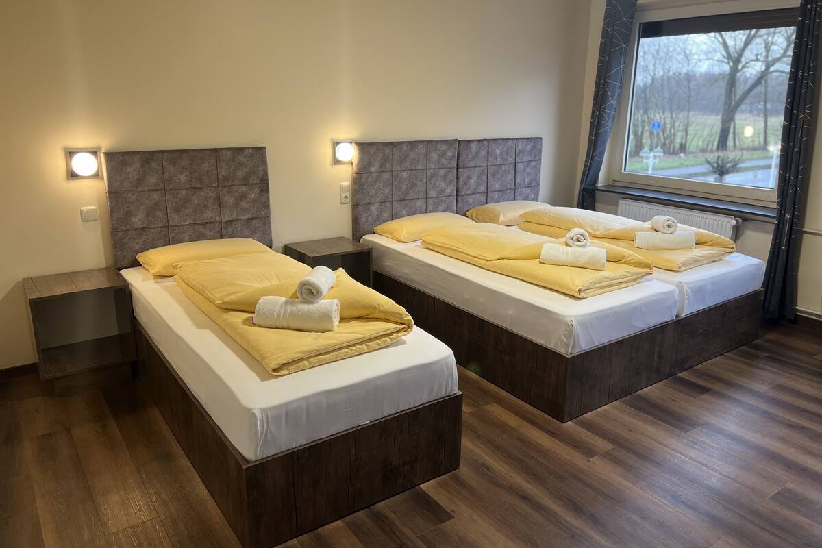 Une chambre d’hôtel avec deux lits, chacun doté d’une tête de lit, de tables de chevet et de serviettes.