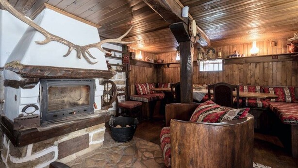 A rustic interior with a stone fireplace, wooden benches, and a high ceiling. - Villa Viara in Rural Pchelnik (Pchelnik)