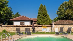 A swimming pool with lounge chairs and a building with a tiled roof. - Villa Viara in Rural Pchelnik (Pchelnik)