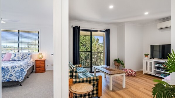 A bedroom with a bed, bedside table, and window blinds. - The Weekender - spacious townhouse in central location (Evans Head)