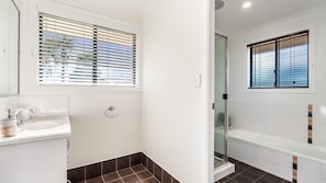 A modern bathroom with a shower, a toilet, and a sink. - The Weekender - 4-46 Cypress Street (Evans Head)
