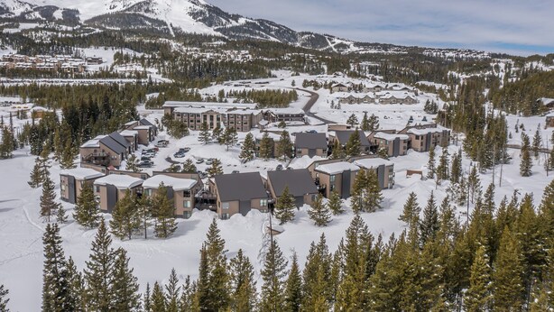 A snow-covered resort with multiple buildings, a ski slope, and a mountain in the background. - Newly remodeled studio w/gorgeous mountain views near Big Sky Resort - Hill Condo Lookout (Big Sky)