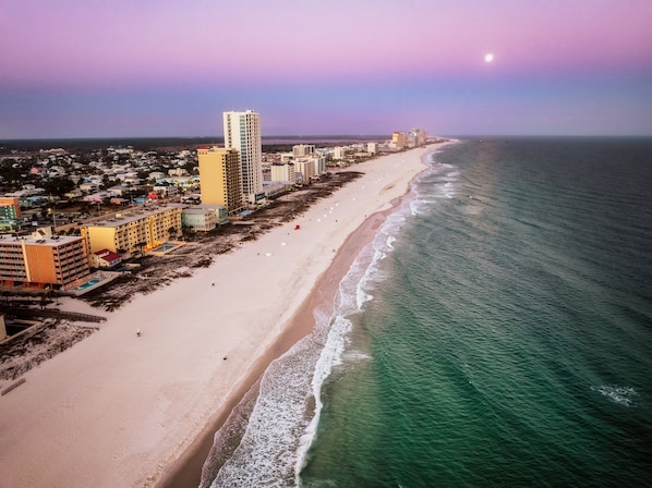 Un paisaje urbano costero con playa, edificios altos y cielo despejado.