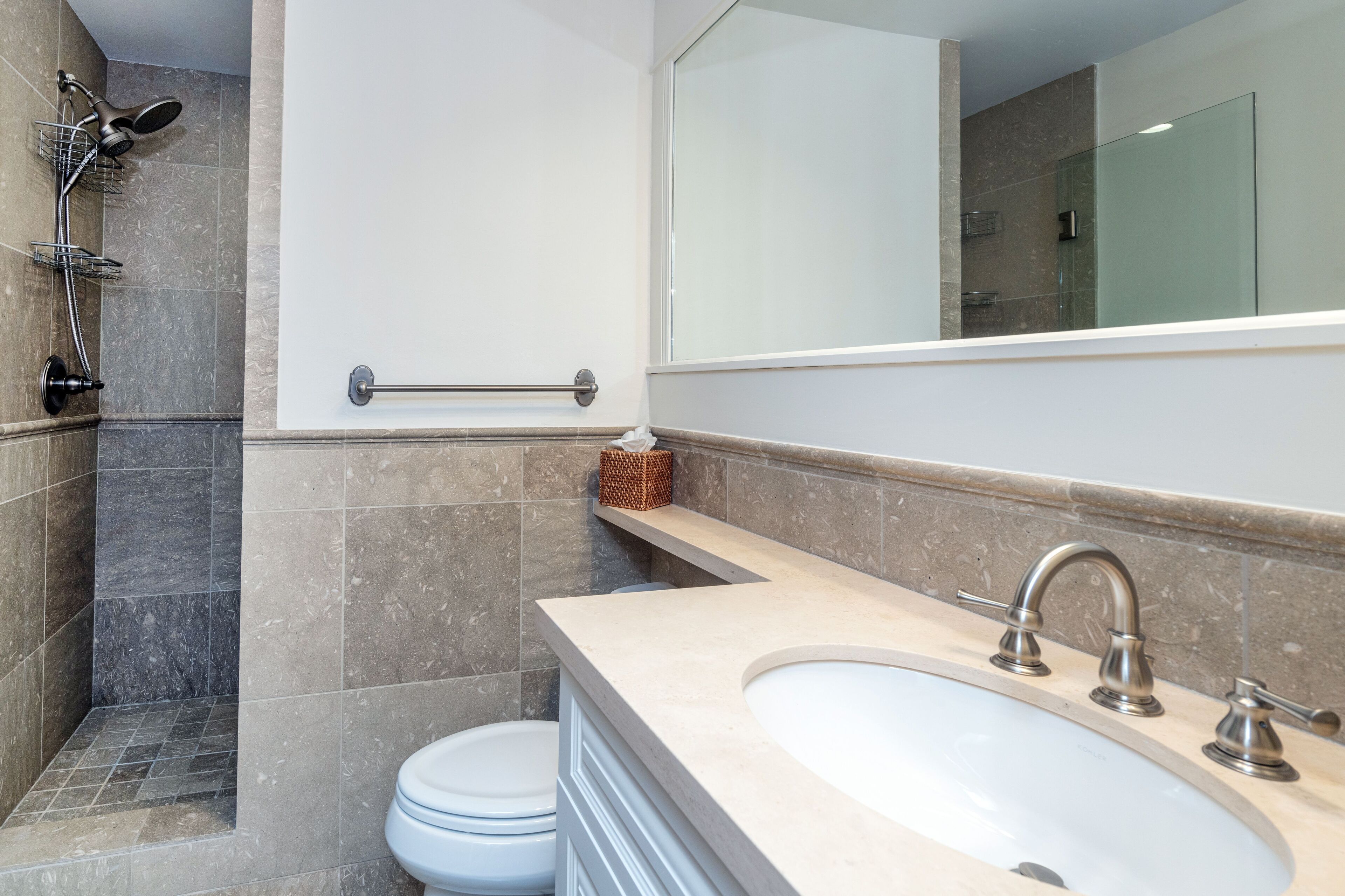 A modern bathroom with a bathtub, a shower, and a toilet.