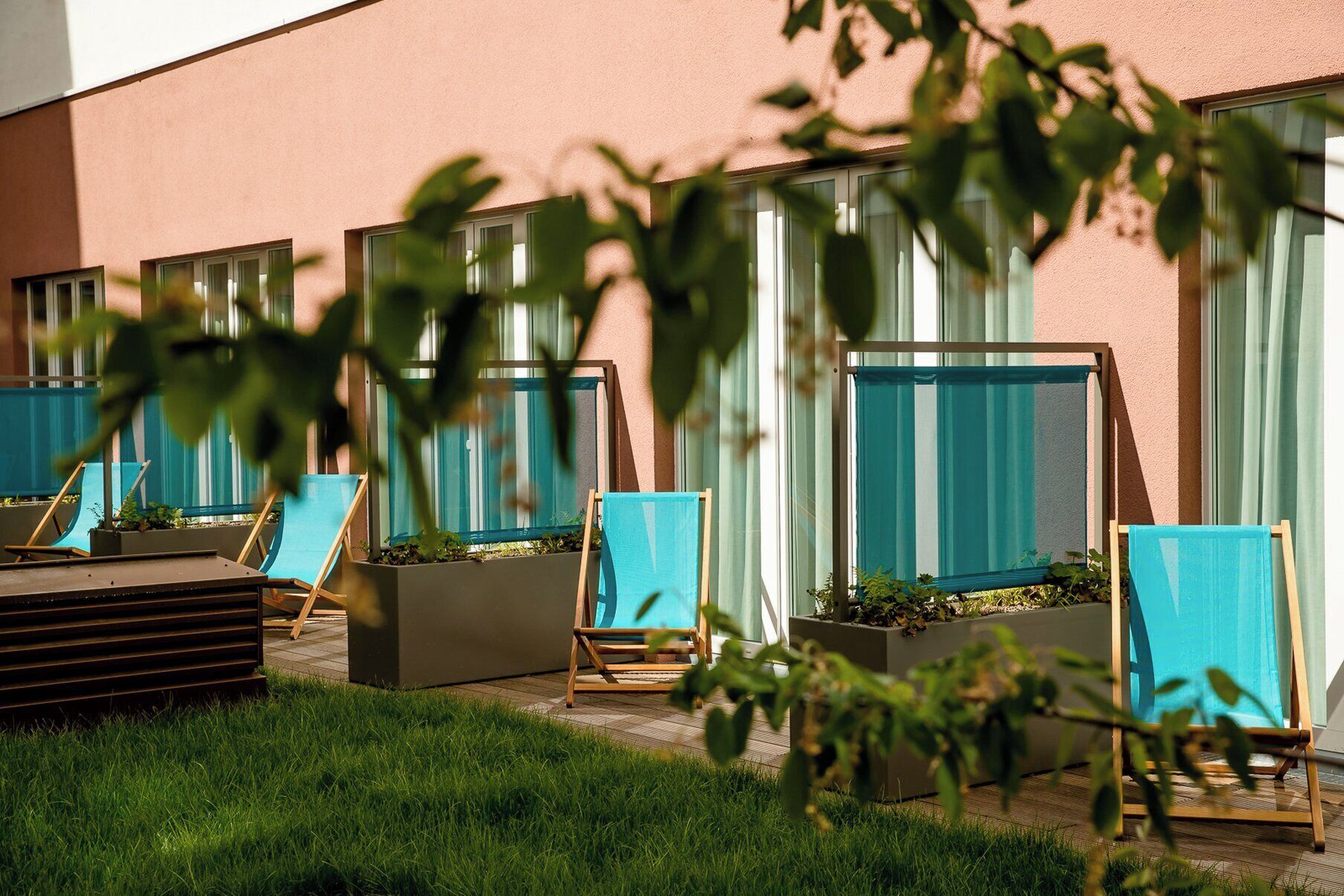 Outdoor seating areas with planters and a building facade.