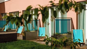 Outdoor seating areas with planters and a building facade.