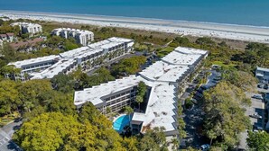 An aerial view of a hotel complex with multiple buildings, parking areas, and a beachfront. - Soak Up the Ocean Air Seaside Villa Stay Near the Sand (Hilton Head Island)