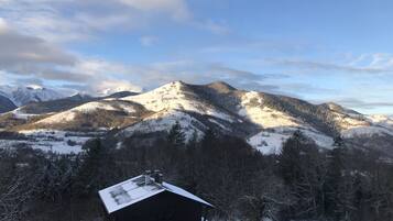 Un paysage de montagne avec une cabane au premier plan.