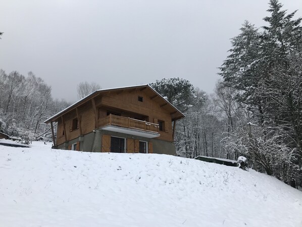A wooden chalet with a balcony, surrounded by snow-covered trees. - Mountain cabin with a garden and a magnificent view (Asté)
