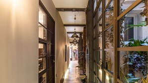 A narrow hallway with wooden flooring, metal-framed glass doors, and hanging pendant lights. - Waou Boutique SOL I (Madrid)