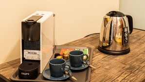 A coffee maker, a kettle, and a tray with cups and condiments on a wooden table. - Waou Boutique SOL I (Madrid)