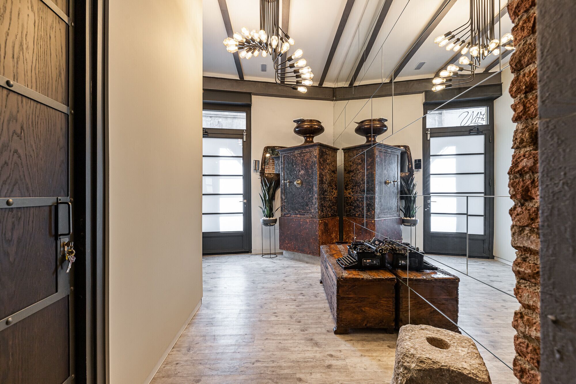 Un interior moderno con piso de madera, un banco de piedra y una pared de piedra.