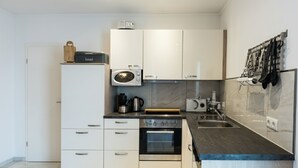 A modern kitchen with white cabinets, a built-in oven, a microwave, and a coffee maker. - 🌸 5-star luxury "Orchidee": Your private spa resort on 85 m² (Arnbruck)