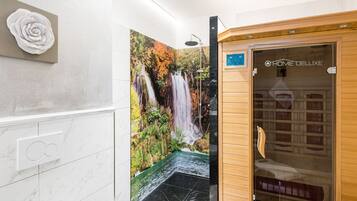 Experience a serene atmosphere in this bathroom with a stunning mural of a waterfall and forest scene.