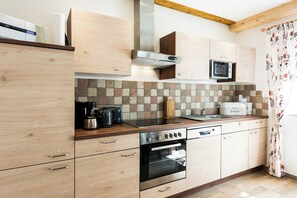 A modern kitchen with wooden cabinets, a built-in microwave, a toaster, and a coffee maker.