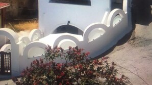 Un bâtiment blanc doté de fenêtres en arc de cercle et de balcons, un drapeau et un ciel dégagé.
