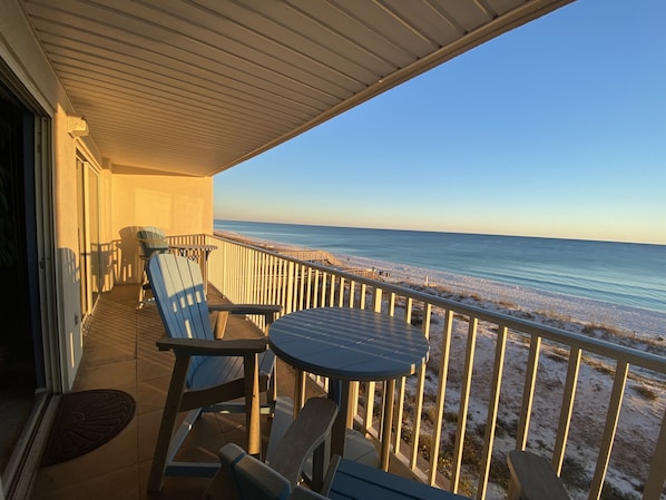 Un balcon fermé offrant une vue sur la plage.