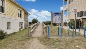 Un escalier en bois mène à un bâtiment sur lequel on peut lire une enseigne indiquant « Oyster Shell » et un panneau « INTERDIT DE STATIONNER ».