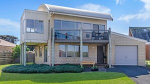 A two-story house with a balcony, a garage, and a well-maintained lawn. - Southern Waves - Views of the Southern Ocean (Port Fairy)