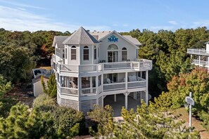 Un immeuble blanc à plusieurs étages, doté d’un balcon et d’une enseigne sur laquelle on peut lire « Mermaid Tales ».