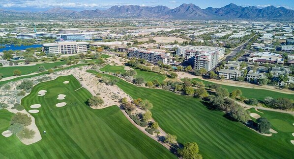 An aerial view of a golf course with a residential area and buildings in the background. - Kierland/Scottsdale 2BR  Gated, Pool, Spa, 2 car Garage, Universal EV charger (Phoenix)