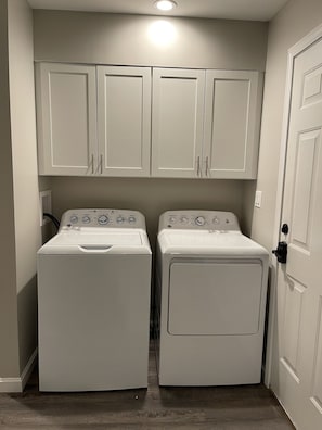 Convenient laundry facilities with two front-loading washing machines and storage above.