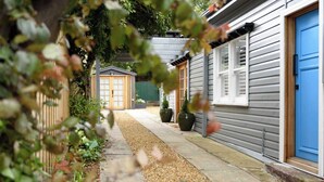 A pathway leading to a row of houses with a blue door on the right. - Prospect Cottage Ballarat (Golden Point)
