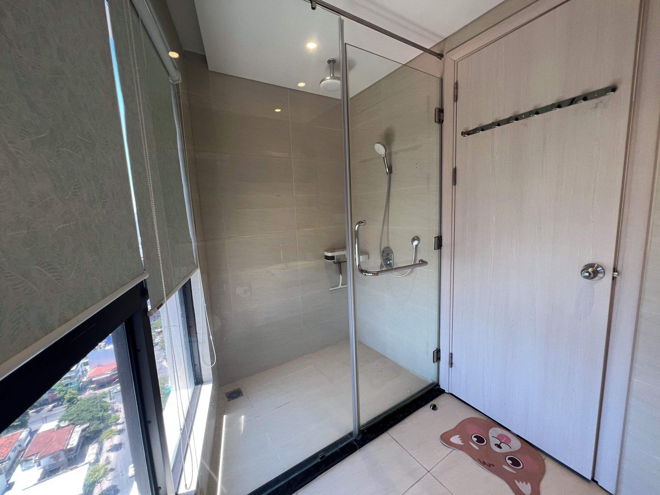 A modern bathroom with a glass shower enclosure, a toilet, and a sink.