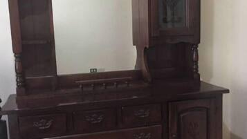 A wooden dresser with a large mirror and multiple drawers.