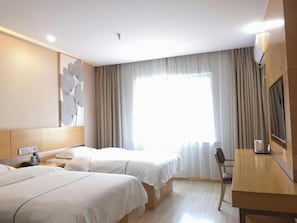 Habitación de hotel con dos camas, un escritorio, una silla y un ventanal con cortinas.
