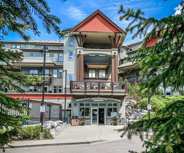 A multi-story hotel with a prominent entrance, balconies, and a stone facade.