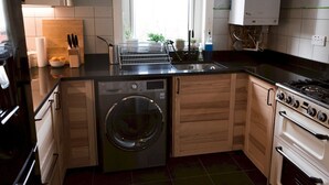 A compact kitchen with a built-in washer, oven, and stove.