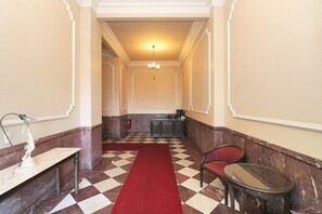A hallway with a checkered floor, a red carpet, a marble bench, and a small table. - Rio Spot Homes T037 Ocean View (Rio de Janeiro)