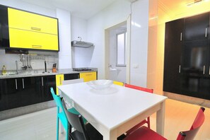A kitchen with a white table, chairs, and a yellow cabinet. - Rio Spot Homes T037 Ocean View (Rio de Janeiro)
