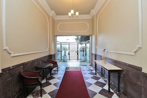 A hotel lobby with a checkered floor, a red carpet, a chandelier, and a statue. - Rio Spot Homes T037 Ocean View (Rio de Janeiro)