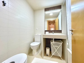 Een bad, een bidet, handdoeken, zeep