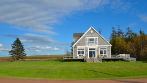 A two-story house with a porch, a deck, and a garage.