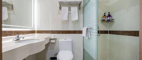 A bathroom with a sink, toilet, and shower area.