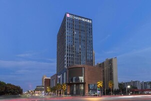 Un moderno edificio de gran altura con un cartel llamativo en la parte superior.