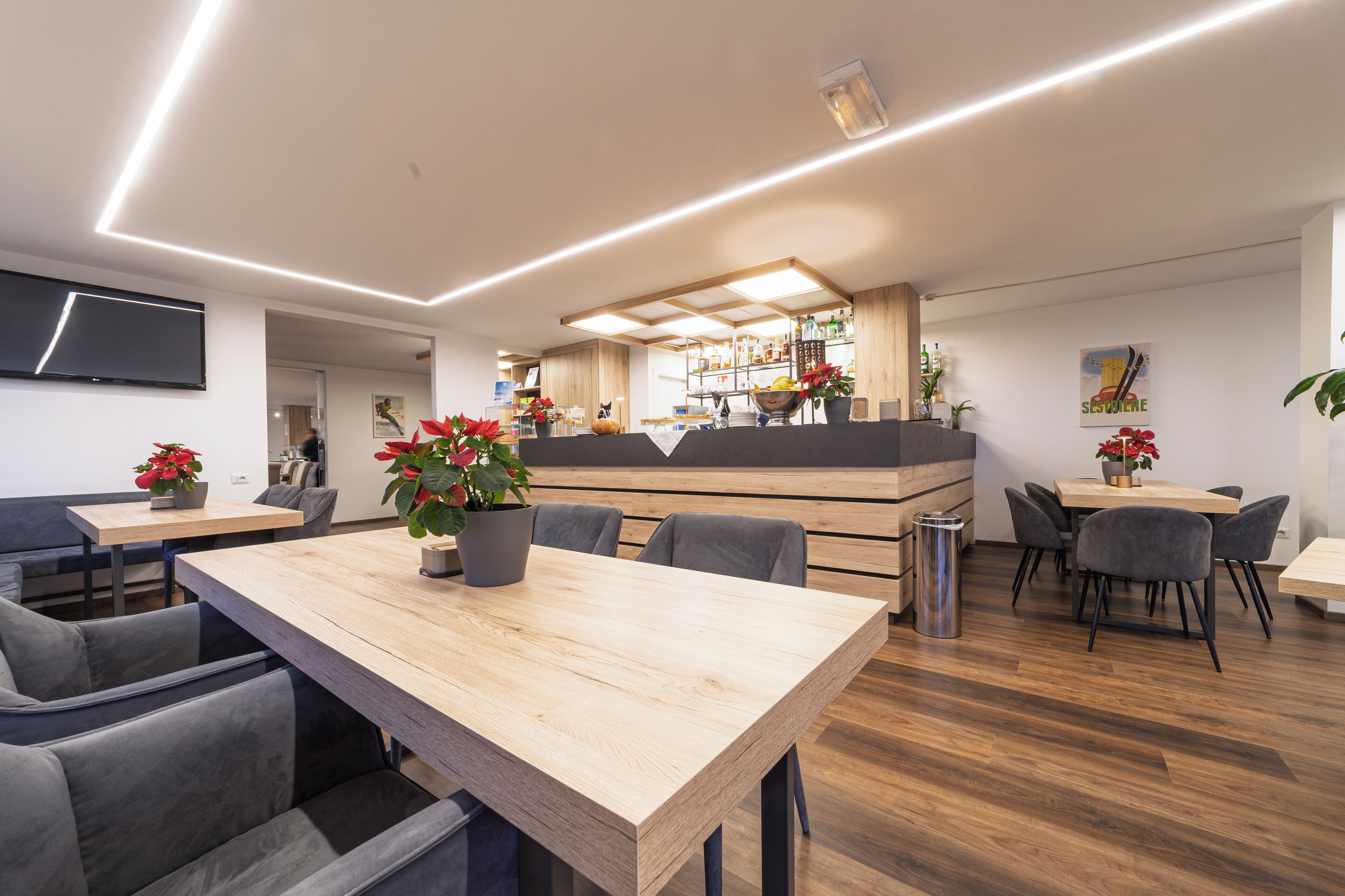 Un restaurant moderne avec des tables en bois et des chaises grises recouvertes de tissu.