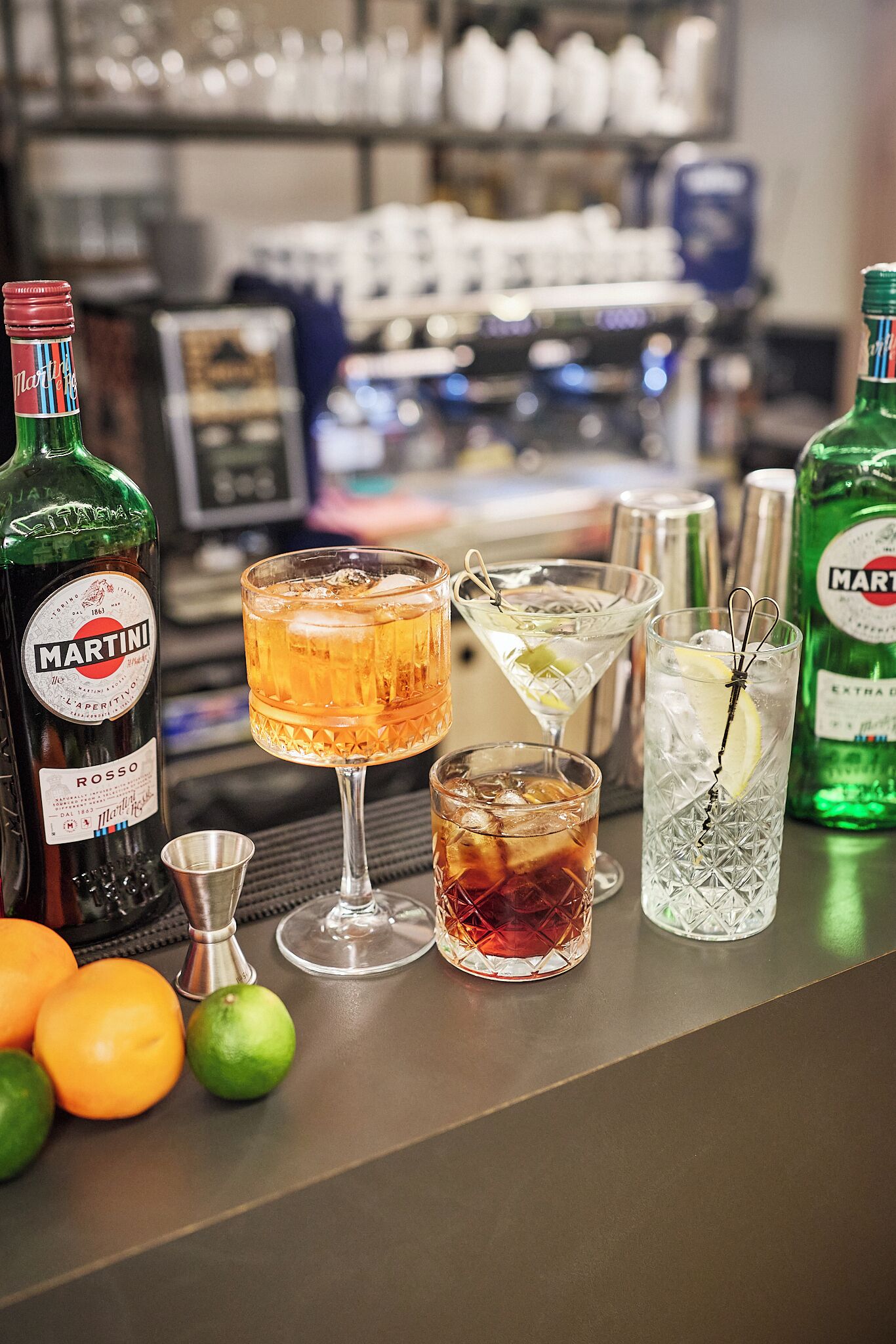 Eine Bar mit Martini Rosso Flaschen, unterschiedlichen Gläsern und Limetten.
