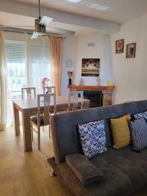A living room with a sofa, a dining table with chairs, a fireplace, and a ceiling fan. - LUXURY SEMI-DETACHED HOUSE IN VERA PLAYA 200 M FROM THE SEA (Vera)