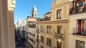 A multi-story building with balconies and a street view. - Hostal Manuela by gaiarooms (Madrid)
