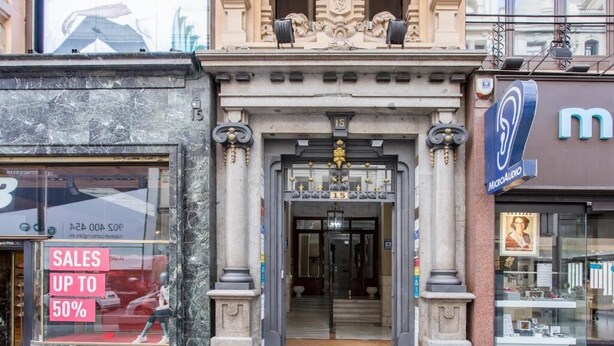 A building entrance with a sales sign, a MicroAudio store, and a staircase leading inside. - Hostal Manuela by gaiarooms (Madrid)